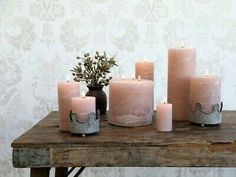 five pink candles sitting on top of a wooden table