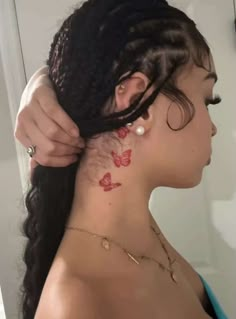 a woman is getting her hair done with butterfly tattoos