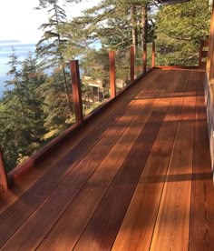 a wooden deck overlooking the water and trees