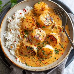 a bowl filled with rice and scallops on top of a white table cloth