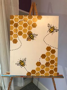 an easel holding up a painting with bees on it