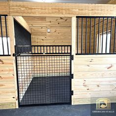 the inside of a horse barn with wooden walls and black iron bars on the doors