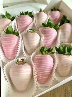 a box filled with pink striped strawberries on top of a table