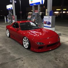 a red sports car parked at a gas station