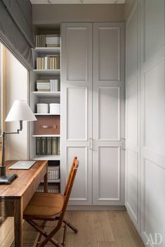 a chair sitting in front of a wooden desk next to a book shelf filled with books