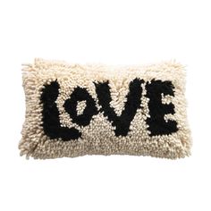 a black and white pillow with the word love on it's side, in front of a white background