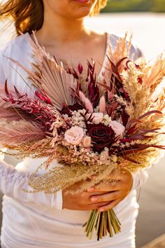 a woman holding a bouquet of flowers in her hands