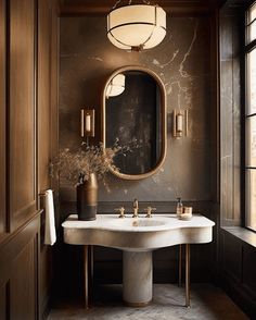 a bathroom with a sink, mirror and vase on the counter in front of it