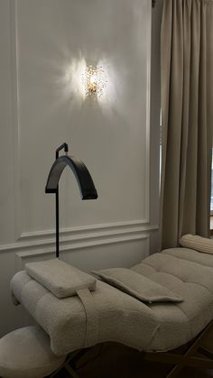 a light that is on in the corner of a room next to a chair and window