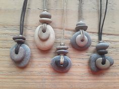 four necklaces made out of stones on a wooden surface with one hanging from the back