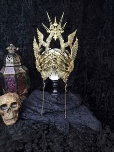 there is a skull wearing a crown next to a candle and other items on the table