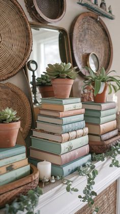 books are stacked on top of each other in front of a fireplace mantel with succulents