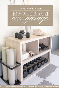 a white shelf with black dumbs on it and a sign that says how we organize our garage