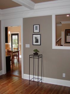 a living room with wood floors and pictures on the wall