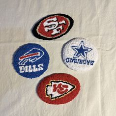 four nfl coasters on a white table cloth