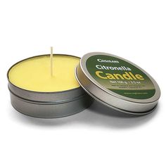 an open tin candle with a stick sticking out of it's top, on a white background