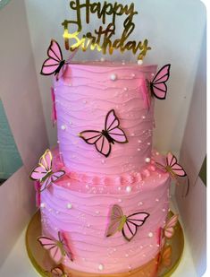 a pink birthday cake with butterflies on it