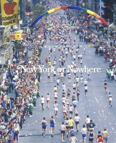 a large group of people running down a street in a marathon race with the words new york for now here