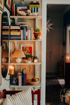 a living room filled with furniture and bookshelves next to a doorway leading into a dining room