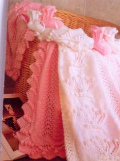 three crocheted blankets laying on top of a wicker basket