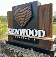 the sign for kenwood vineyards is displayed in front of purple flowers and trees