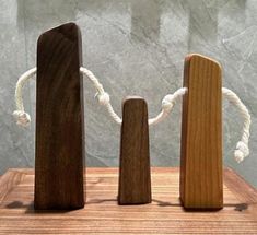 three pieces of wood sitting on top of a wooden table next to ropes and rope