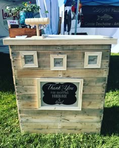 a wooden box with a chalkboard sign on the side and some flowers in it