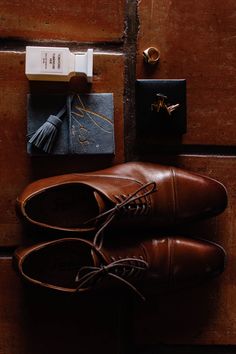 a pair of brown shoes sitting on top of a wooden floor