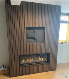 a modern fireplace with wood paneling on the wall and fire place in front of it