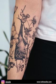 a person with a tattoo on their arm holding a flower and a bat in the air