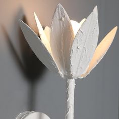 a white vase with a flower in it