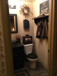 a bathroom with a toilet, sink and shelf above it's door is shown