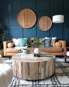 a living room filled with furniture next to two wall hangings and a rug on the floor