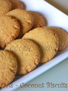 some cookies are on a white plate with the words coconut biscuits in front of them