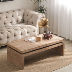 a living room with a couch, coffee table and lamp on the rug in front of it