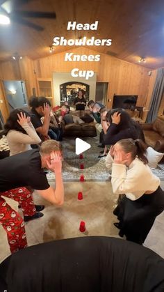 a group of people sitting in a living room with their hands up to the ceiling