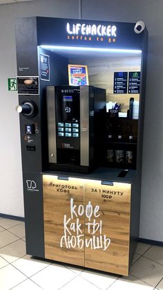 a vending machine that has some writing on the side of it and is next to a tile floor