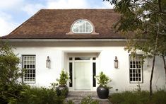 a white house with potted plants in front