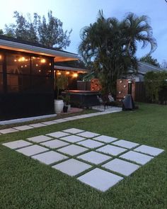 a backyard with grass and lights in the evening