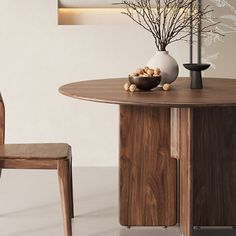 a wooden table with two chairs next to it and a vase filled with flowers on top