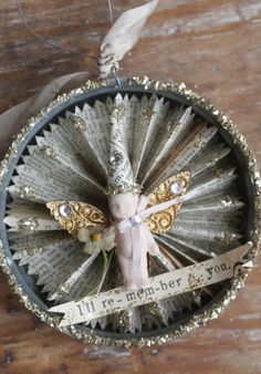 an ornament made out of old book pages with a ribbon tied to it