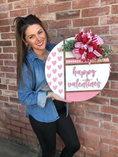 a woman holding a sign that says happy valentine's day