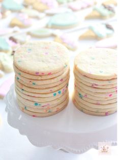 several cookies stacked on top of each other with sprinkles in the background