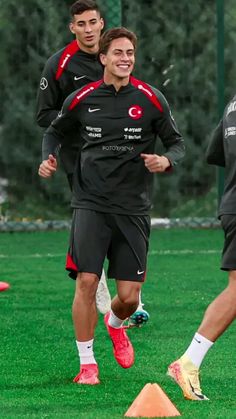 two soccer players are running on the field