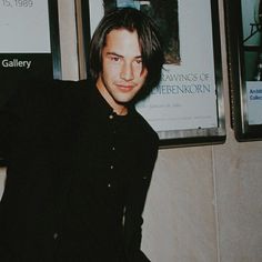 a man standing in front of a movie poster