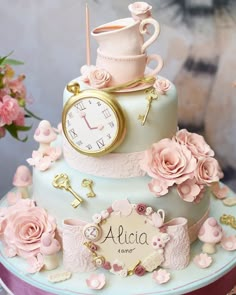 a three tiered cake decorated with pink flowers and an ornate clock on the top