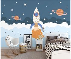 a bedroom with a rocket ship mural on the wall and other space related items around it