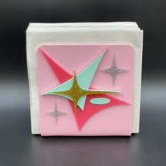 a pink and green box with silver stars on it