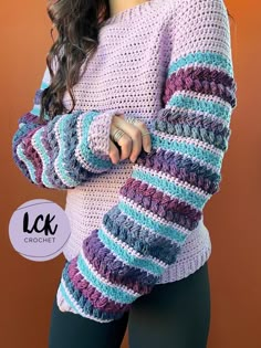 a close up of a woman wearing a sweater with crochet on the sleeves