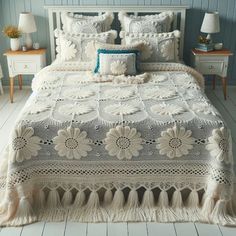 a bed with white bedspread and pillows on top of it in a room